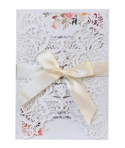 Elegant laser cut white wedding invitation card with floral pattern and cream satin ribbon