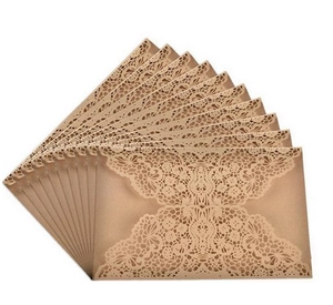 Macro detail of laser-cut vintage floral pattern on brown kraft paper invitation card
