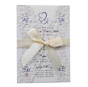 Elegant white laser-cut lace wedding invitation with a silk ribbon and purple inner card
