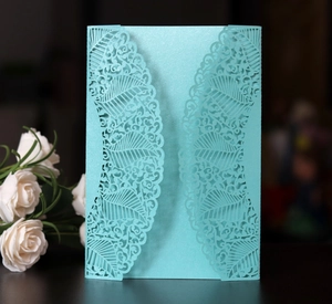 Detailed laser-cut Tiffany blue invitation cover with pearlescent floral leaf patterns