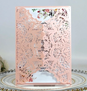 Detailed laser-cut rose gold invitation card with floral insert on elegant ceramic plate
