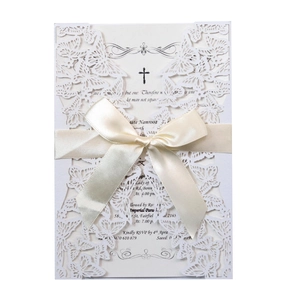 Elegant white laser-cut butterfly wedding invitation with ribbon and cross detail