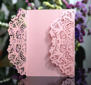 Detail of pink laser-cut wedding invitation cover with elegant lace and floral patterns