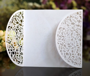 Elegant white laser-cut floral wedding invitation card with intricate hollow pattern