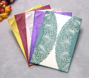 Detailed laser-cut wedding invitations with intricate floral lace and geometric patterns