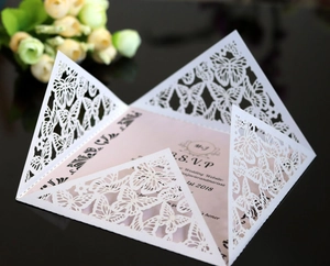 Detailed close-up of laser-cut butterfly hollow wedding invitation with elegant pearlescent paper