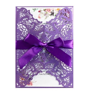 Detailed laser-cut purple wedding invitation featuring floral print and satin ribbon bow