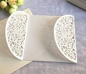Detail view of laser cut rose pattern on cream pearlescent wedding invitation with envelope