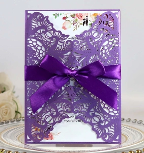 Detailed laser cut purple wedding invitation with ribbon bow and floral inner page