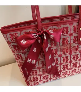 Detailed view of red wedding tote with double happiness jacquard and silk ribbon accent