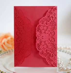 Detailed laser-cut dark red wedding invitation with elegant floral lace patterns