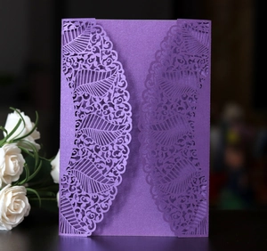 Detail of laser-cut purple invitation sleeve with intricate European lace floral patterns