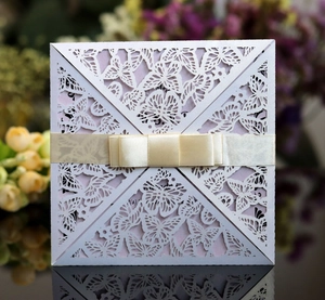 Detail of laser-cut butterfly invitation card with purple pearlescent paper and satin bow