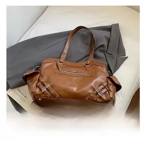 Close-up of vintage brown tote bag with metal buckles and multiple zipper pockets