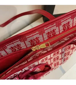 Detail of red jacquard wedding tote featuring golden zipper and Double Happiness patterns