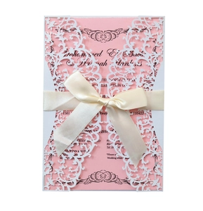 Elegant laser cut wedding invitation with pink card, white lace cover and silk bow