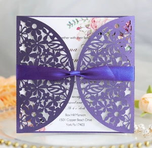 Detailed laser-cut purple floral wedding invitation featuring a lavender silk ribbon bow