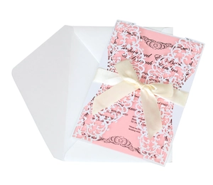 Elegant white laser-cut wedding invitation with pink insert card and cream ribbon bow
