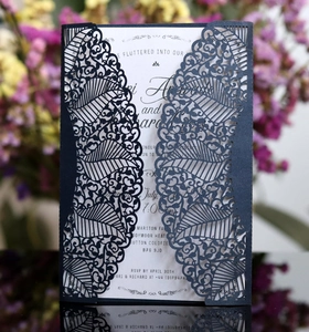 Detail of laser-cut lace invitation cover with fine vein texture and white insert card
