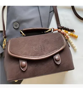 Detailed view of brown matte leather handbag with branded logo and colorful wood beads