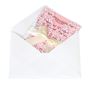Laser cut white lace wedding invitation set with a pink insert card and white satin bow
