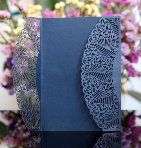 Detail of navy blue laser-cut invitation card with leaf pattern and shimmering texture