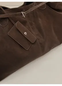 Detail of dark brown suede tote bag featuring a detachable card pouch and metal snap button