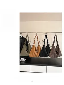 Detail view of four large casual crossbody bags with pleated shoulder straps in earthy tones