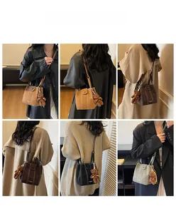 Detail showing various colors of the minimalist bucket bag with a small bear pendant accessory