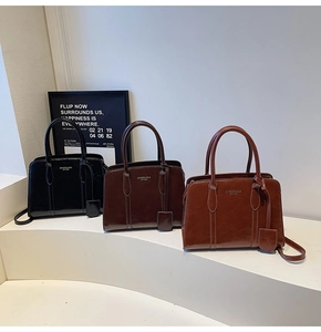 Three elegant PU leather handbags in black, dark coffee, and brown red on display