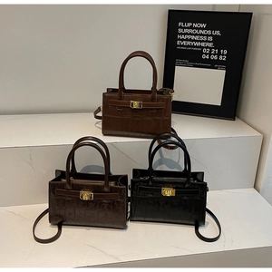 Detailed view of crocodile pattern crossbody bags in black, brown, and tan colors