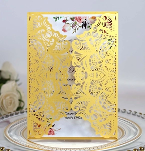 Macro view of laser-cut gold mandala wedding invitation with floral insert and elegant patterns