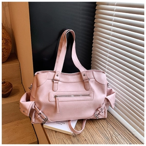 Detail of pink PU leather tote bag with multi-pocket design and silver metal hardware