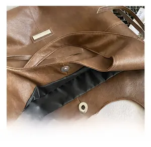 Close-up of brown tote bag showing magnetic buckle, black lining and internal storage space