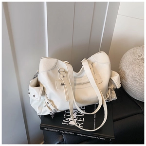 Detailed view of the large white vintage tote bag on a book with metal buckle straps