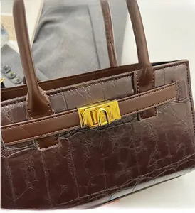 Close-up of crocodile pattern leather handbag with gold hardware and strap details