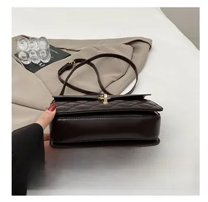 Detail of dark brown quilted shoulder bag with gold twist lock and smooth leather texture