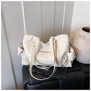 Detailed shot of a beige vintage tote bag with rivets on a minimalist leather seat