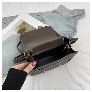 Detail view of brown vintage crossbody bag showing interior pocket and white stitching