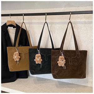 Hanging display of vintage tote bags in khaki, black and brown with cute bear charms