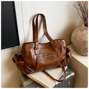 Detail of dark brown vintage tote bag with functional pockets and wrinkled leather texture