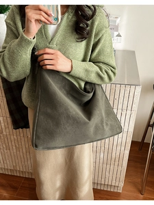 Detail of olive green suede hobo bag with textured pleats and matching shoulder strap