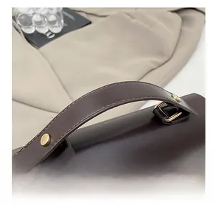 Close-up of premium dark brown leather handle with gold metallic studs and precision stitching