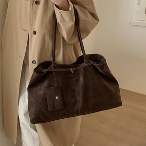 Detail of vintage dark brown suede tote bag featuring a decorative buckle and long strap