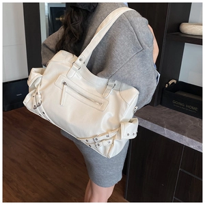 Detail of white biker style tote bag showing textured faux leather and metal zippers