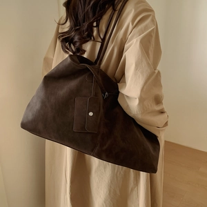 Detail of dark brown faux suede tote bag featuring a large capacity minimalist design