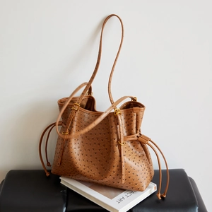 Detail of ostrich texture leather tote bag with drawstring and slim shoulder strap
