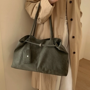 Detail of olive green matte leather tote bag with side straps and matching coin purse