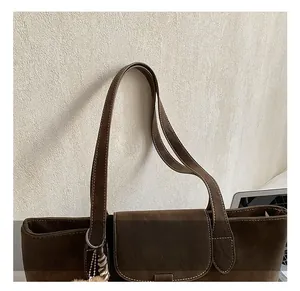 Detail showing the comfortable double handles and white stitching on the vintage brown tote