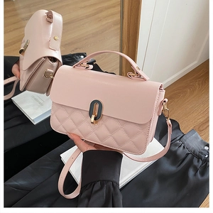 Detail of pink quilted handbag showing gold twist lock and elegant top handle texture